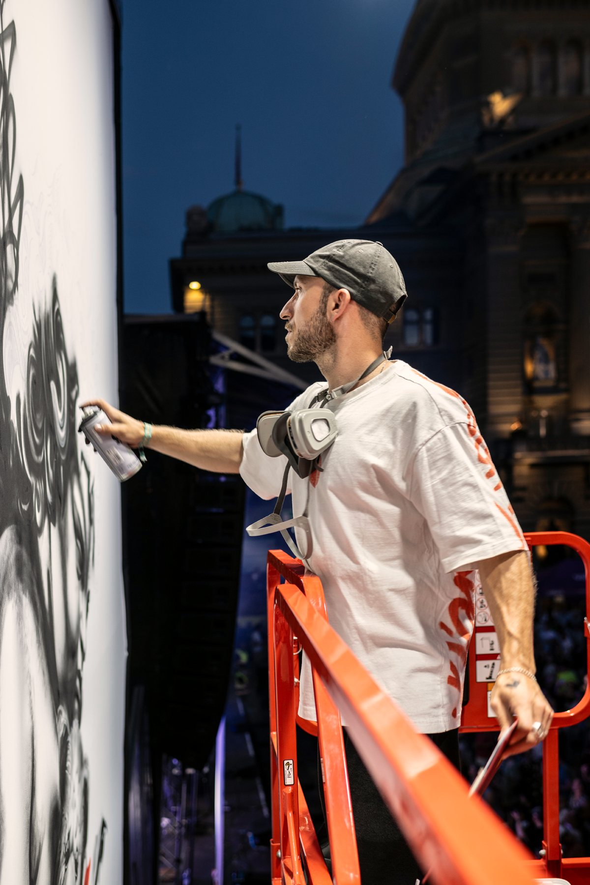 Der Künstler Vierwind bei der Arbeit am Kunstwerk auf der Hebebühne vor dem Bundeshaus